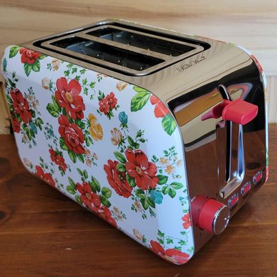 Pioneer Women ,2 Slice Toaster, w/ Red Floral Pattern on White Background.